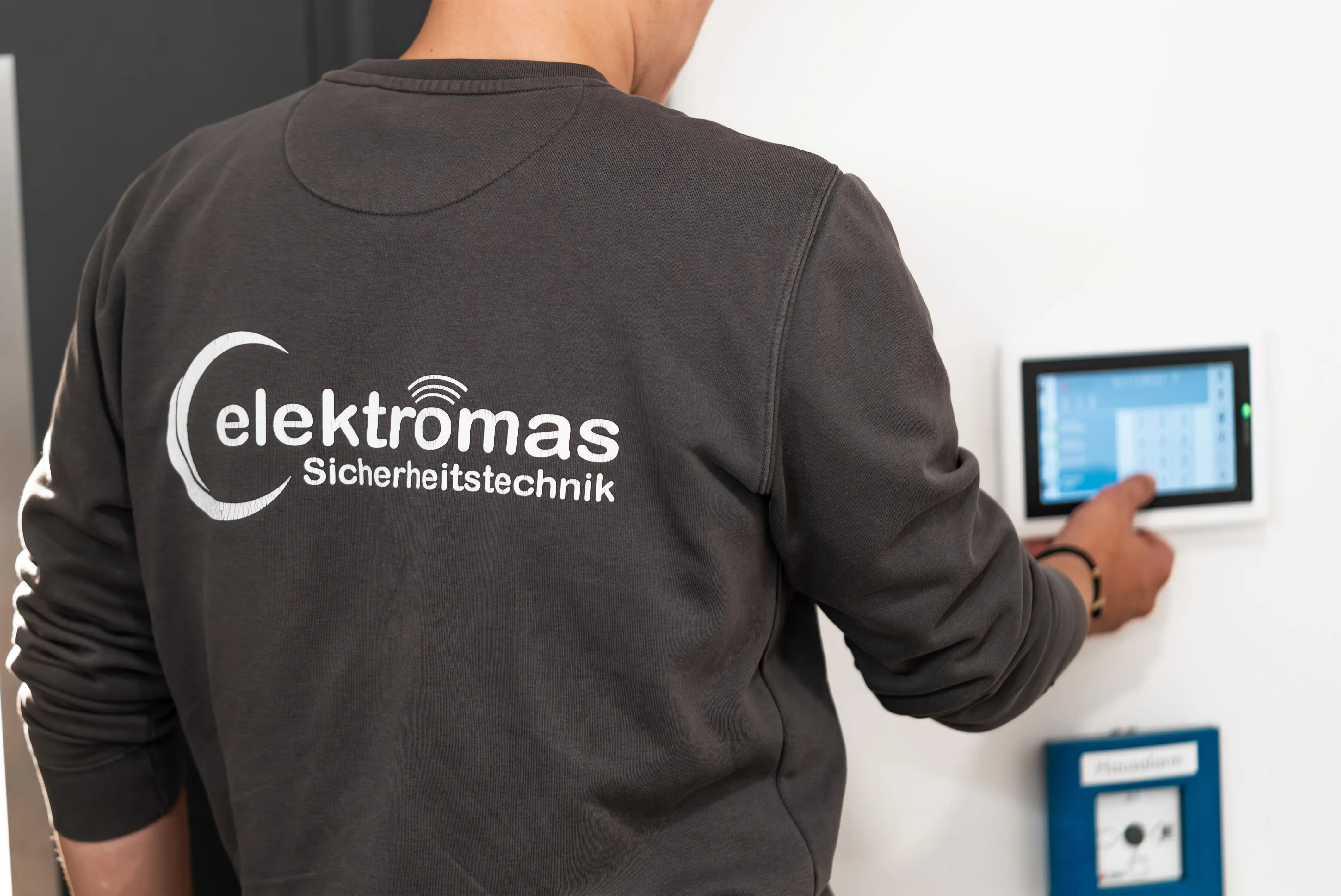 Mitarbeiter der elektromas Sicherheitstechnik GmbH bedient das Bedienteil einer Einbruchmeldeanlage